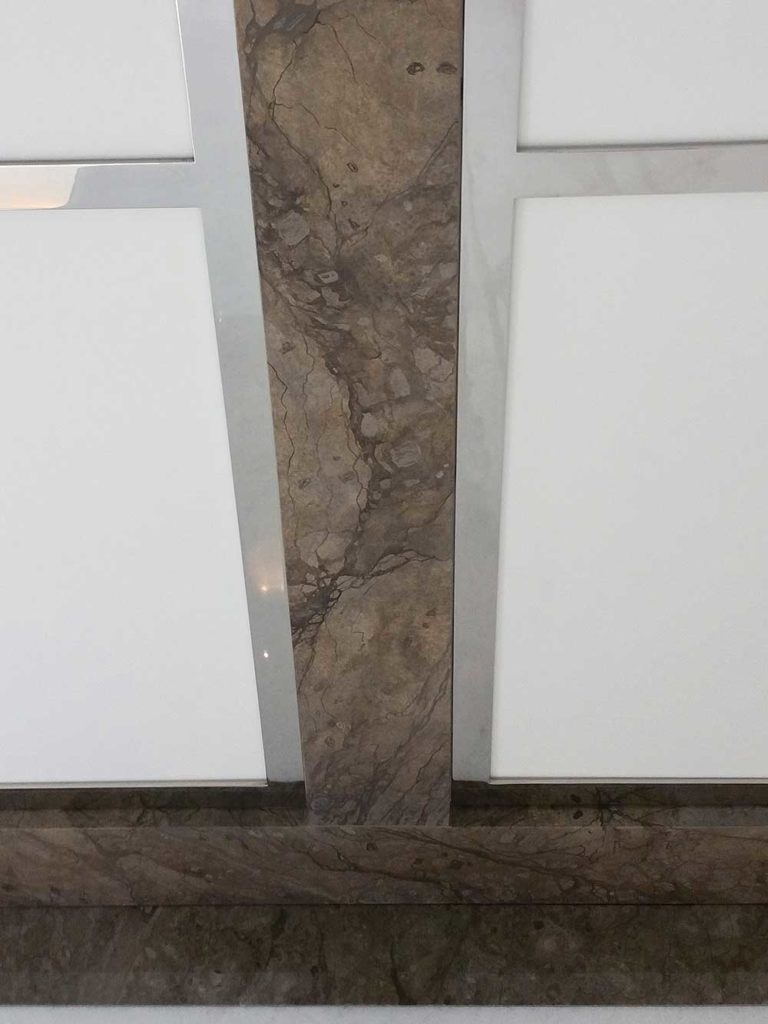 laster ceiling straps are treated to a hand painted faux marble finish to match the marble border on the walls.